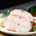 Whole red rockfish resting on a pale surface